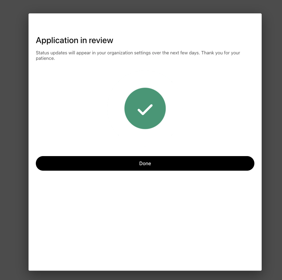 Application in review confirmation screen with a large green checkmark and a Done button. Subheading reads Status updates will appear in your organization settings over the next few days.